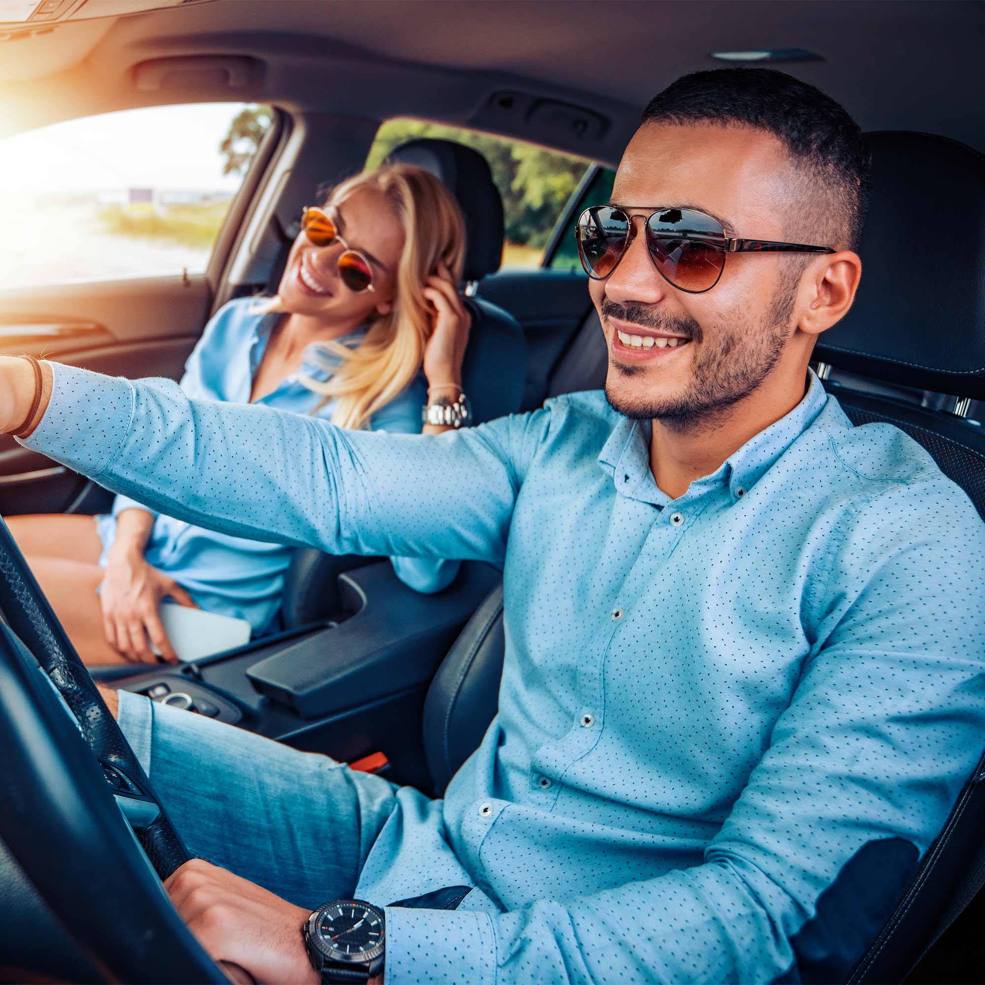 Man and woman driving in a truck with sunglasses on.